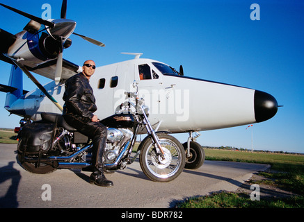 Ein Mann auf einem Motorrad vor einem Flugzeug Schweden. Stockfoto