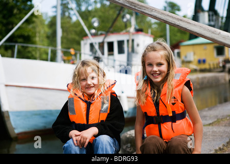 Mädchen sitzt neben einer Schleusenkammer Stockfoto