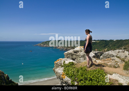 Dh Moulin Huet Bay St Martin Guernsey junge Frau mit Blick auf die Bucht und die südliche Küste Ansichten Mädchen person Walker Stockfoto