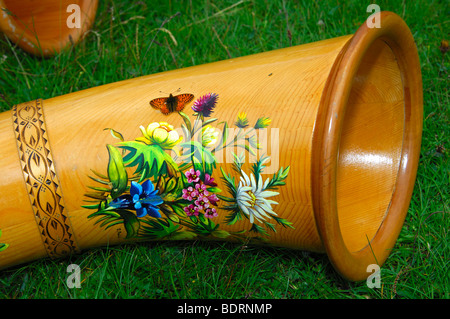 Alphorn dekoriert mit Blumenmotiven aus den Alpen und ein Schmetterling, Schweiz Stockfoto