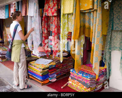 Westliche Frau Tourist Wahl eines indischen Stoff Schal aus einem Geschäft in Chamba. Himachal Pradesh. Indien. Stockfoto