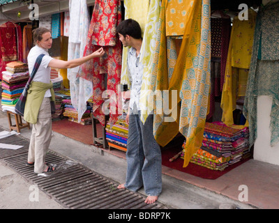 Westliche Frau Tourist Wahl eines indischen Stoff Schal aus einem Geschäft in Chamba. Himachal Pradesh. Indien. Stockfoto