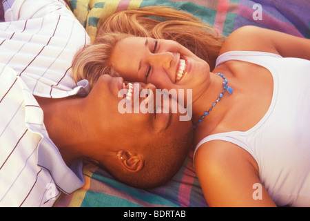 junge interracial paar auf einer Decke liegend Stockfoto
