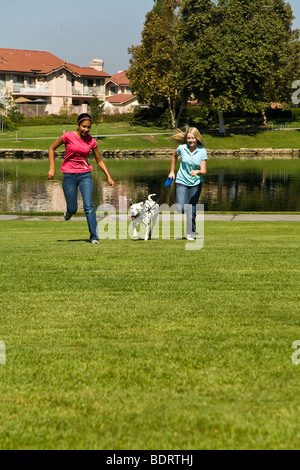 Zwei jugendlich Mädchen hängen heraus hängen zusammen Hispanic & Kaukasische Mädchen 12-14 Jahre alten laufen Dalmatiner Hund vorne USA Myrleen USMR © Pearson Stockfoto