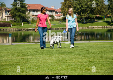 Vorderansicht zwei Mädchen hängen zusammen hängen Hispanic kaukasischen Mitte Mädchen im Teenageralter dalmatinischen sprechen Kind spielen spielt Hund Besitzer Herr © Myrleen Pearson entfernt Stockfoto