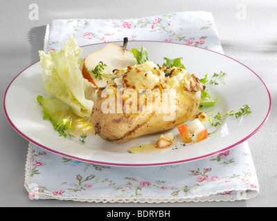 Kartoffelgratin mit Birne und Salat auf einem Teller mit einem floral Serviette Stockfoto