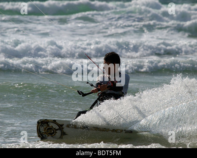 Kitesurfer beschleunigt durch die Wellen bei Les Pieux, Normandie, Frankreich Stockfoto