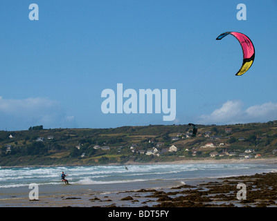 Kitesurfer beschleunigt durch die Wellen bei Les Pieux, Normandie, Frankreich Stockfoto