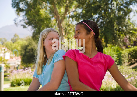 Hispanische und kaukasischen Tween Tweens 11 – 12 Jahre alt-jährigen sitzen und Spaß im Park, die einander gegenüber stehen Flächen. Herr © Myrleen Pearson Stockfoto