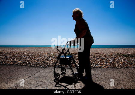 Ältere Frau mit walking Frame am Strand Stockfoto