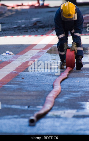 Ein Feuerwehrmann rollt ein Schlauch während der Zeit nach dem 30. April 2007 Dale Street-Feuer in Manchester, England. Stockfoto