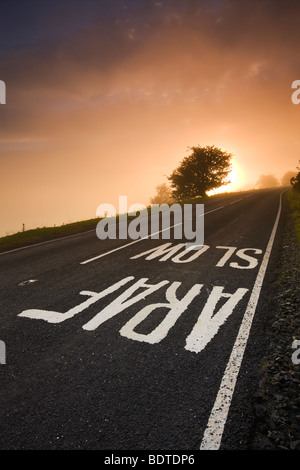 Straßenschild auf einer Heide-Straße auf einen nebligen Sonnenaufgang, gemalt, Brecon Beacons National Park, Powys, Wales, UK. Sommer (Juni) 2009 Stockfoto