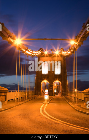 Bangor, Gwynedd, North Wales, UK, Großbritannien. Blick entlang der A5-Straße über die Menai Hängebrücke, Anglesey in der Nacht Stockfoto