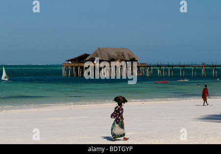 Bunt gekleidete Swahili Dame zu Fuß auf Zanzibar beach Stockfoto