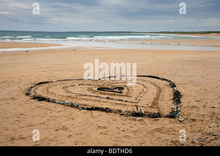 Herzförmiges Muster aus Algen und Steinen; Strandkunst und Sanddünen Küstenlandschaft in Fraserburgh Bay, Aberdeenshire, Schottland, Großbritannien. Stockfoto