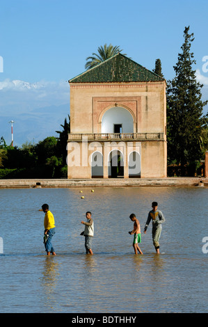 Marokkanische jungen Wade über den See oder den Pool vor dem Menara Royal Pavillon in Marrakesch Menara-Gärten, Marokko Stockfoto