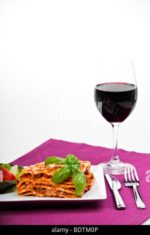 Lasagne al Forno auf einem Teller mit Rotwein Stockfoto