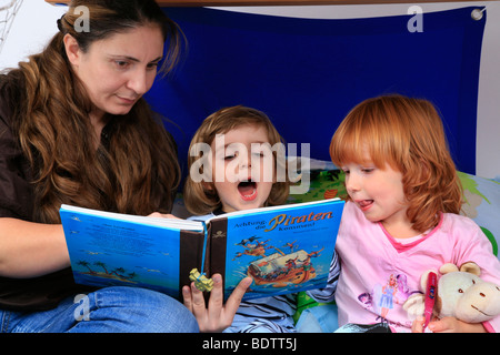 Mutter ein Buch über Piraten zu ihren Kindern in ein Billi-Bolli Hochbett Stockfoto