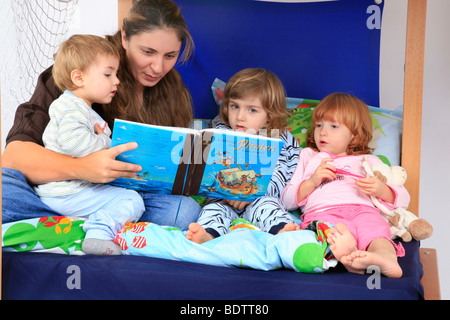 Mutter ein Buch über Piraten zu ihren Kindern in ein Billi-Bolli Hochbett Stockfoto