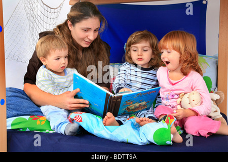 Mutter ein Buch über Piraten zu ihren Kindern in ein Billi-Bolli Hochbett Stockfoto