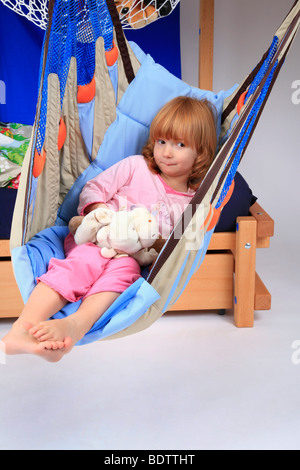 kleines Mädchen in einem Schwung ein Billi-Bolli Hochbett Stockfoto