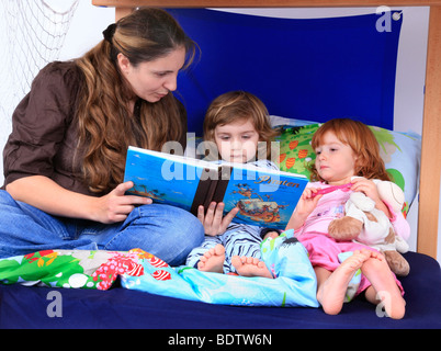 Mutter ein Buch über Piraten zu ihren Kindern in ein Billi-Bolli Hochbett Stockfoto