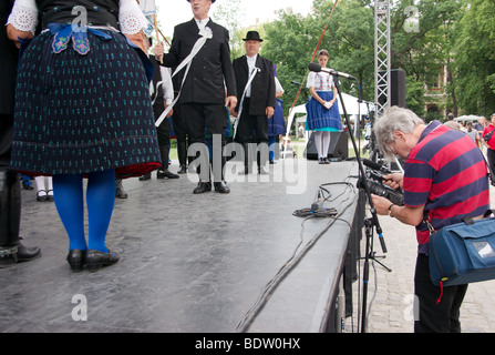 Ungarischer Tänzer in Tracht auf einem Volksfest in Budapest durchführen. Ein Fotograf ist die Szene aufnehmen. Stockfoto