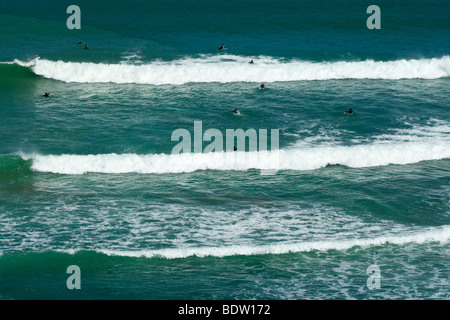 eine Reihe von Surfer warten auf die perfekte Welle um zu reiten, Maori Bay, Muriwai Regional Park, North Island, Neuseeland Stockfoto