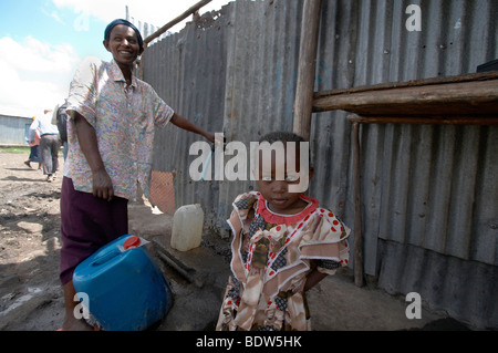 Sammeln von Wasser aus öffentlichen Wasserhahn in Mukuru Ruben, einem Slum von Nairobi Kenia-Frau. Foto: Sean Sprague 2007 Stockfoto