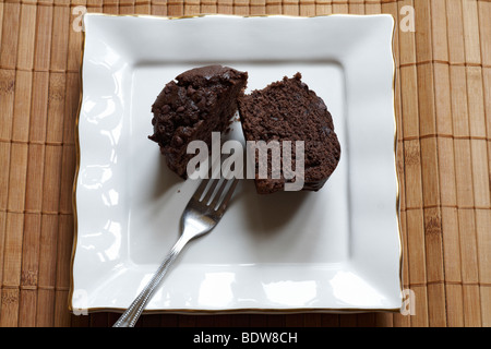 Choc-Chip Muffin auf weißen Teller mit Gabel Stockfoto