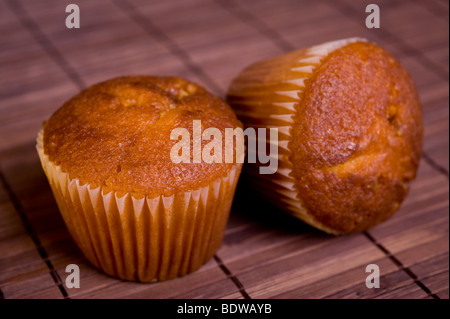 Zwei Muffins auf Bambusmatte, Nahaufnahme, Studio gedreht. Stockfoto