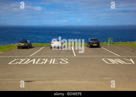 Schlechte Parkmöglichkeiten. Autos parken auf den klar ausgewiesenen Busparkplätzen am Leuchtturm Duncansby Head mit Blick auf das Meer. Caithness, Schottland Stockfoto