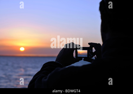 Tourist unter Bild des Sonnenuntergangs mit Digitalkamera, Urangan Harbour, Port Hervey Bay, Queensland, Australien Stockfoto