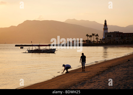 Menschen zu Fuß am Strand in den Abend, Leuchtturm, Boot, Banka, trees Palm, romantische Stimmung, Olongapo City, Subic Bay, Luzon Stockfoto