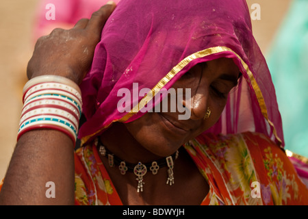 Rajasthan, Indien - Zigeunerin leben in einer nomadischen Camp in der Wüste Thar trägt einen bunten Sari und gibt ein schüchternes Lächeln. Stockfoto