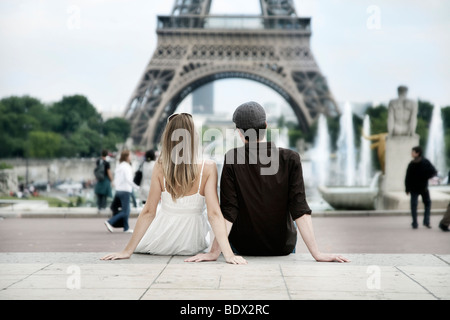 Junges Paar sitzt vor dem Eiffelturm, Paris, Frankreich, Europa Stockfoto