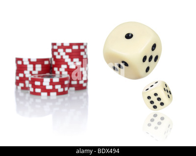 Paar Würfel Rollen vor gestapelten roten Pokerchips. Stockfoto