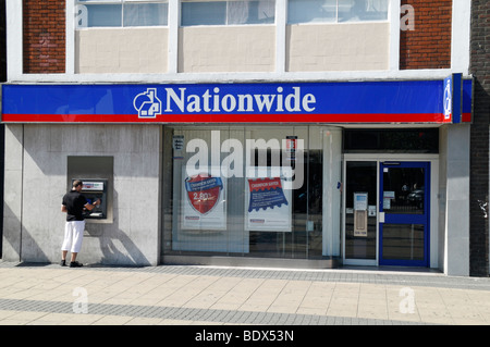 Einen Kunden benutzt den Geldautomaten außerhalb der Nationwide im Zentrum von Stratford, East London, UK. Stockfoto