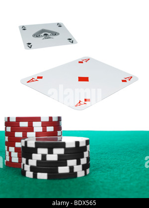 Zwei Asse fliegen über den Pokertisch. Rote und schwarze Chips im Vordergrund. Stockfoto