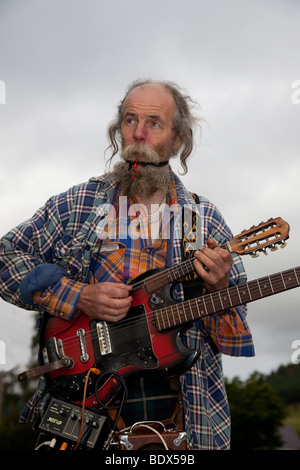 One-man-band, Gaukler, Musiker, spielen eine Reihe von Instrumenten bei Braemar schottischen Highland Games und Sammeln von Pitlochry, Perthshire Schottland, Großbritannien Stockfoto