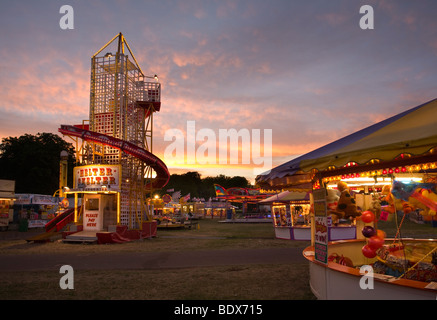 Helter Skelter und Seite zeigen Stände gegen Sonnenuntergang am Mittsommer Fair Cambridge Stockfoto