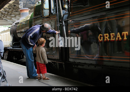 Ein Vater mit seinen Sohn einer Dampfmaschine Kingswear Station in Devon, England Stockfoto