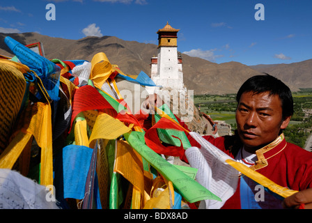 Junge Tibeter in traditioneller Tracht auflegen Gebetsfahnen oberhalb der Yarlung-Tal, Yumbulagang Palast, erste und älteste fortr Stockfoto