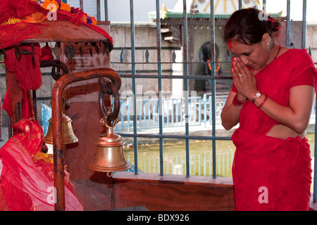 Kathmandu.  Eine Hindu-Frau betet zu Gott Hanuman in einem Viertel-Tempel.  Ein Tika Reis ist Sindur Pulver auf der Stirn. Stockfoto