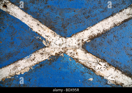 Eine Wetter getragen malte schottische Andreaskreuz auf eine Betonmauer. Stockfoto