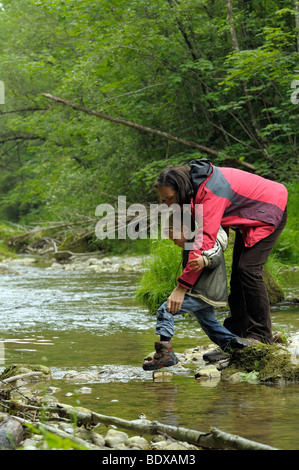 Mutter und Kind, die Überquerung eines Flusses Stockfoto