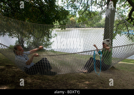 Mann und Frau in einer riesigen Hängematte, Teil von Tree House Gallery, temporäre Installation Regents Park Stockfoto