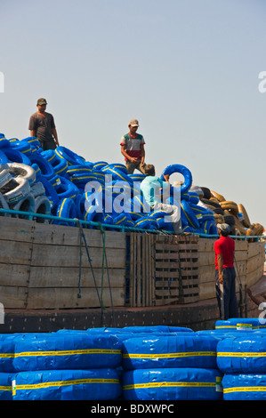 Arbeiter laden Reifen auf einer Dhow Boot im Creek von Dubai Stockfoto