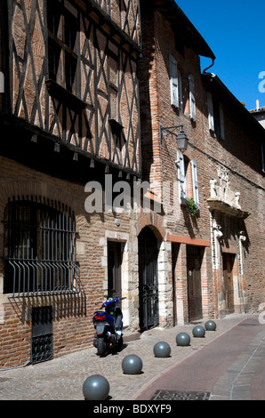 Mittelalterliche Gasse in der Nähe der Kathedrale von Albi, eine bissige Motorrad kontrastieren mit Fachwerk-Architektur Stockfoto