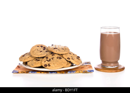 Ein Teller voll mit hausgemachten Schokoladenkekse mit einem kalten Glas Schokolade Milch zu konsumieren bereit. Stockfoto